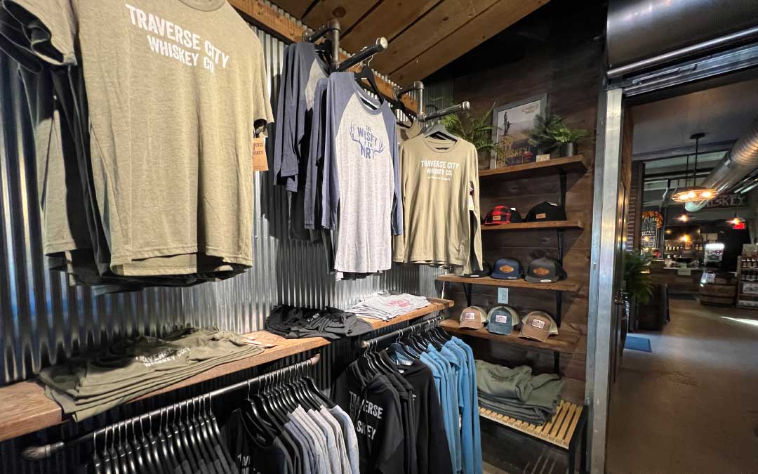 Shirts and hats on merchandise shelves at distillery